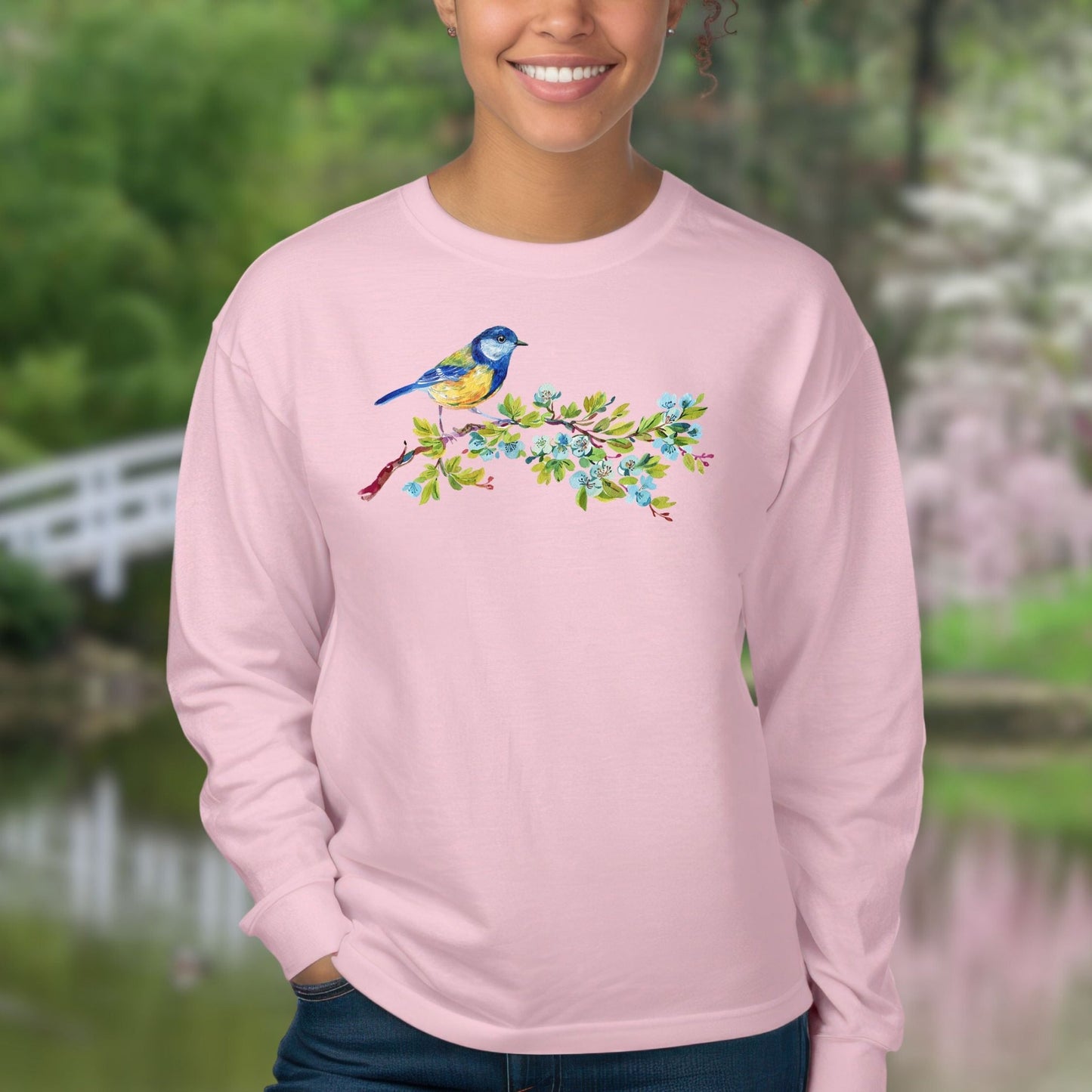 Pink long sleeve tee with a watercolor blue bird on a budding branch design.