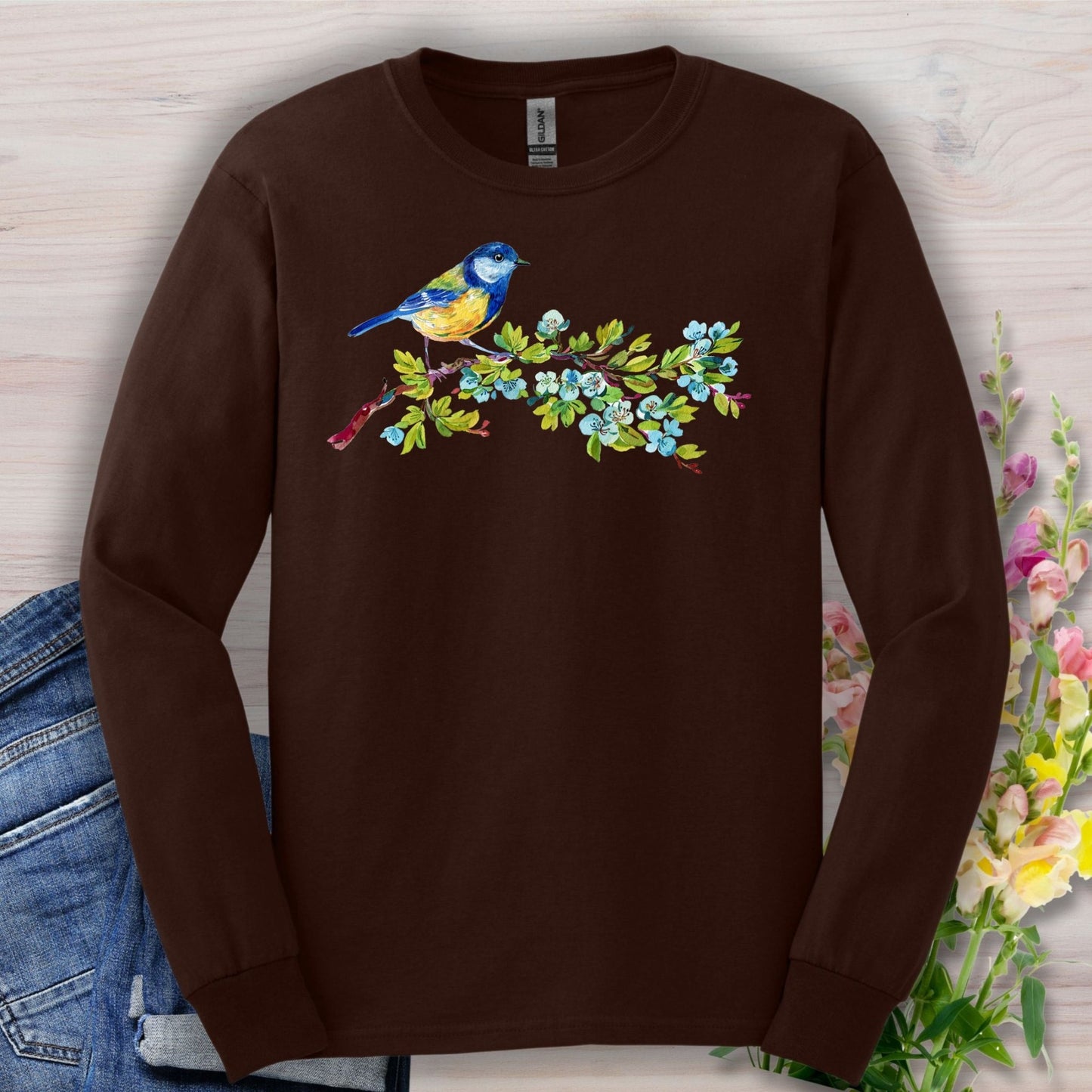 Dark chocolate long-sleeve tee with a watercolor blue bird on a budding branch design.