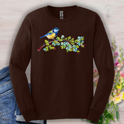 Dark chocolate long-sleeve tee with a watercolor blue bird on a budding branch design.