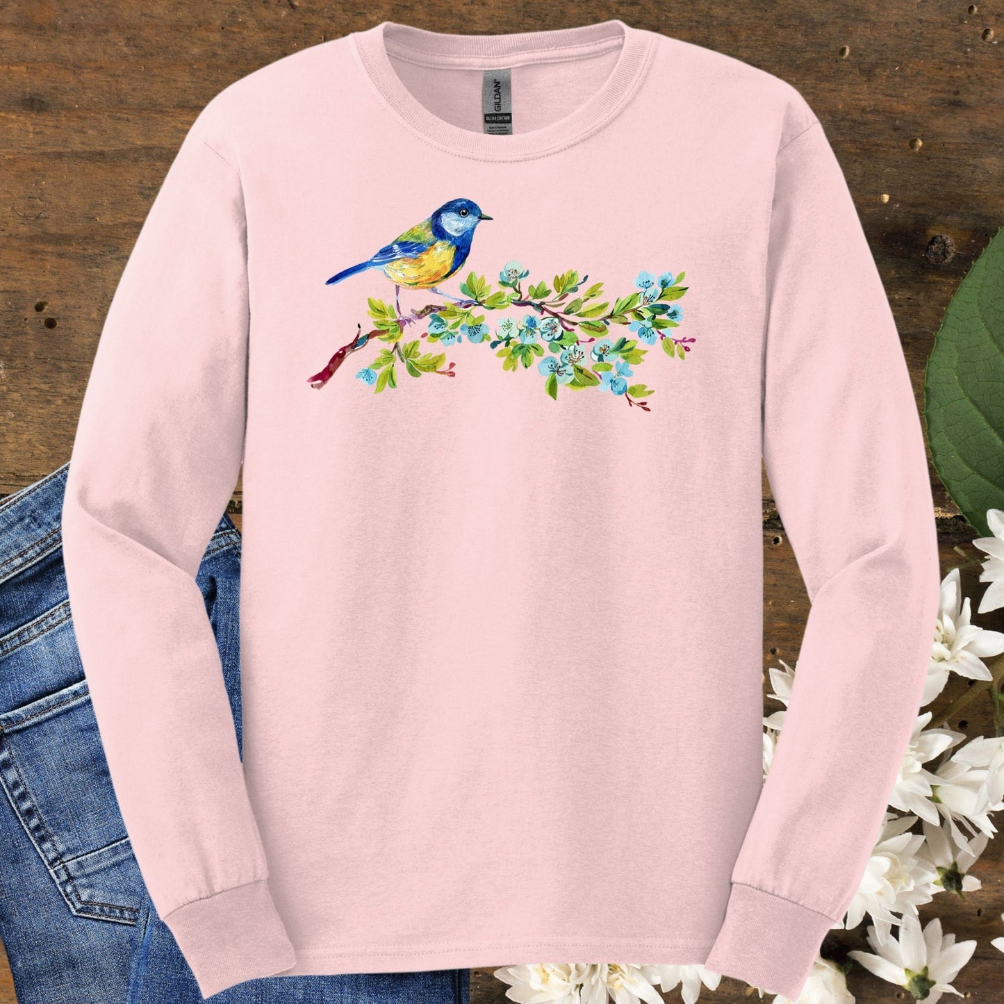Light pink long sleeve tee with a watercolor blue bird on a budding branch design.