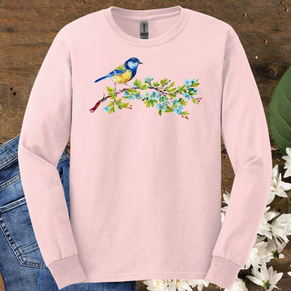 Light pink long sleeve tee with a watercolor blue bird on a budding branch design.