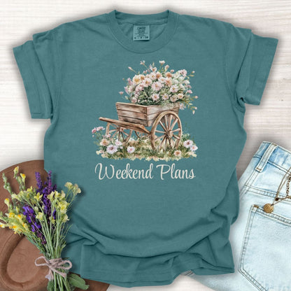Blue Spruce cotton t-shirt with a watercolor gardening wagon overflowing with pink carnations and "Weekend Plans" text.