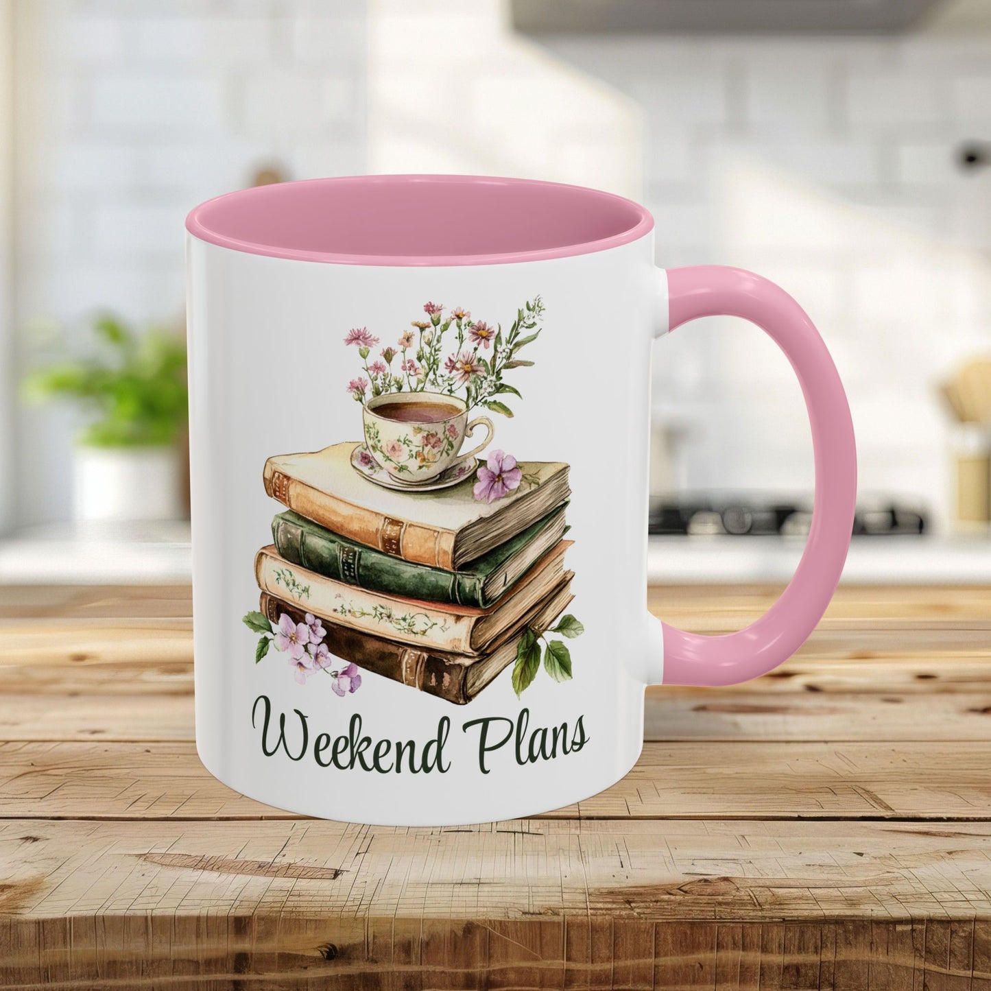 11oz ceramic mug with pink handle and interior, featuring a watercolor stack of books, floral teacup, and "Weekend Plans" text.