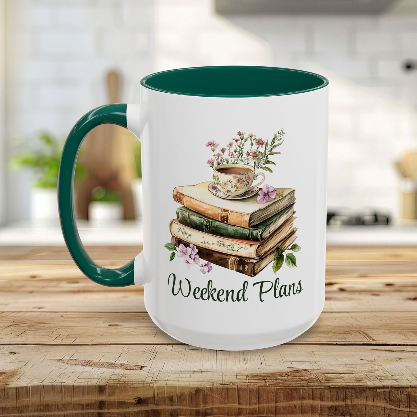 White ceramic mug with a green handle and interior, featuring a watercolor stack of books, a floral teacup, and "Weekend Plans" text.
