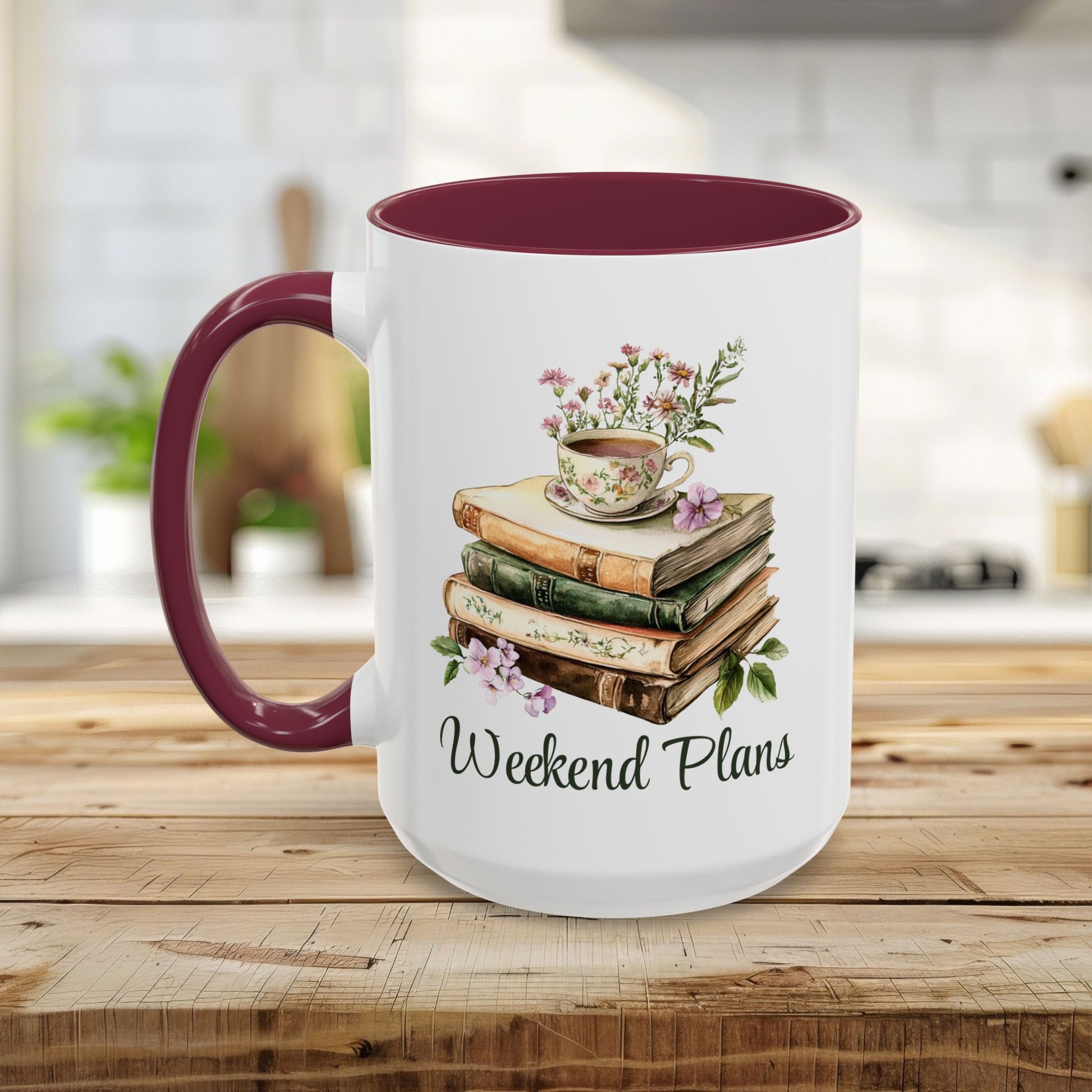 White ceramic mug with a maroon handle and interior, featuring a watercolor stack of books, floral teacup, and "Weekend Plans" text.