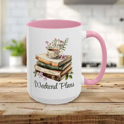 White ceramic 15oz mug with pink handle and interior, featuring a watercolor stack of books, floral teacup, and "Weekend Plans" text.