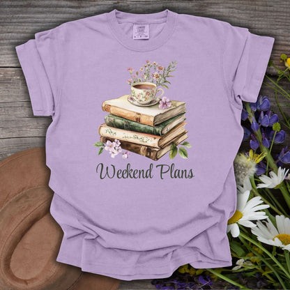Orchid S-size t-shirt with a watercolor stack of vintage books, floral teacup, and "Weekend Plans" text.