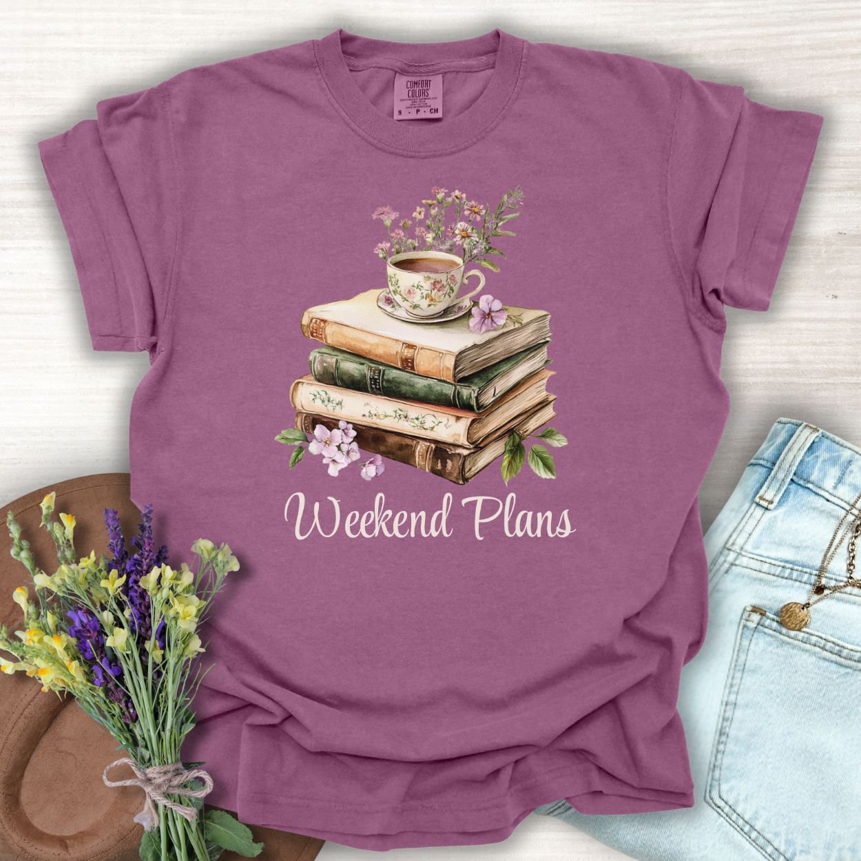 Berry S-size cotton t-shirt with "Weekend Plans" text and watercolor stack of books, teacup, and flowers.