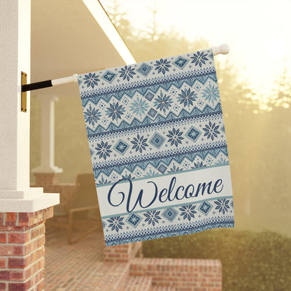 Blue Fair Isle poly poplin garden flag with "Welcome" script, hanging from a porch pole.