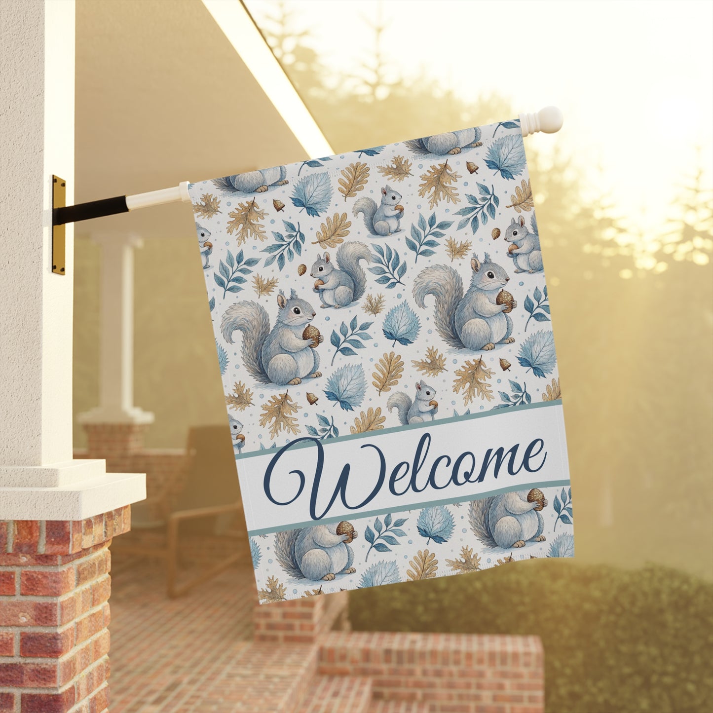 Watercolor squirrel and foliage garden flag with "Welcome" script, hanging on a porch.