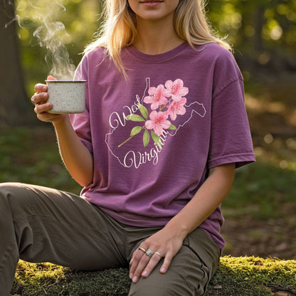 Garment-dyed plum t-shirt with a West Virginia outline and watercolor rhododendron design.