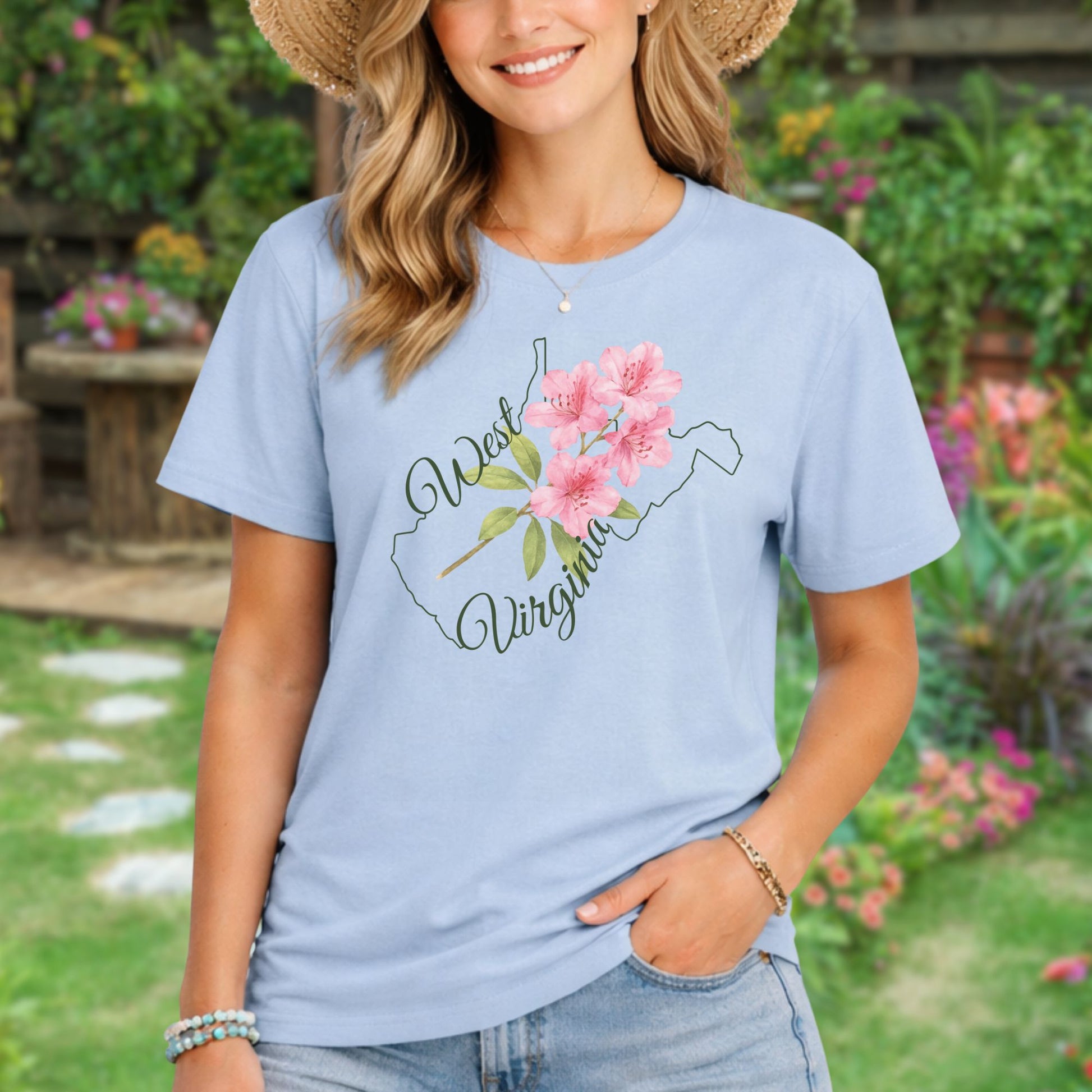 Light blue garment-dyed t-shirt with a watercolor rhododendron and West Virginia state outline.