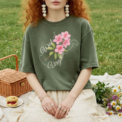 Garment-dyed olive green t-shirt with a white West Virginia outline and pink rhododendron graphic.