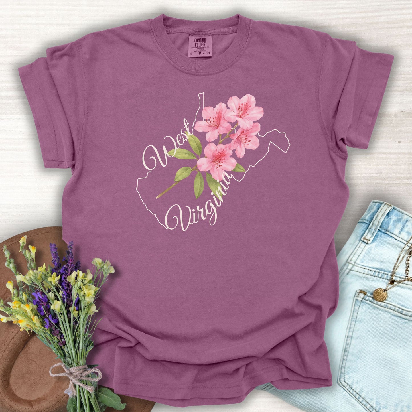 Berry S-size garment-dyed cotton t-shirt with a West Virginia state outline and watercolor rhododendron.