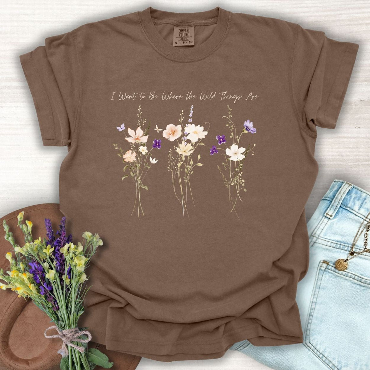 Espresso brown garment-dyed cotton t-shirt featuring watercolor wildflowers and the text I Want to Be Where the Wild Things Are.