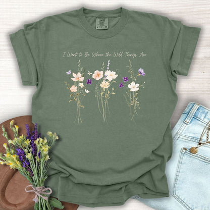 Moss green garment-dyed cotton t-shirt featuring watercolor wildflowers and the text I Want to Be Where the Wild Things Are.