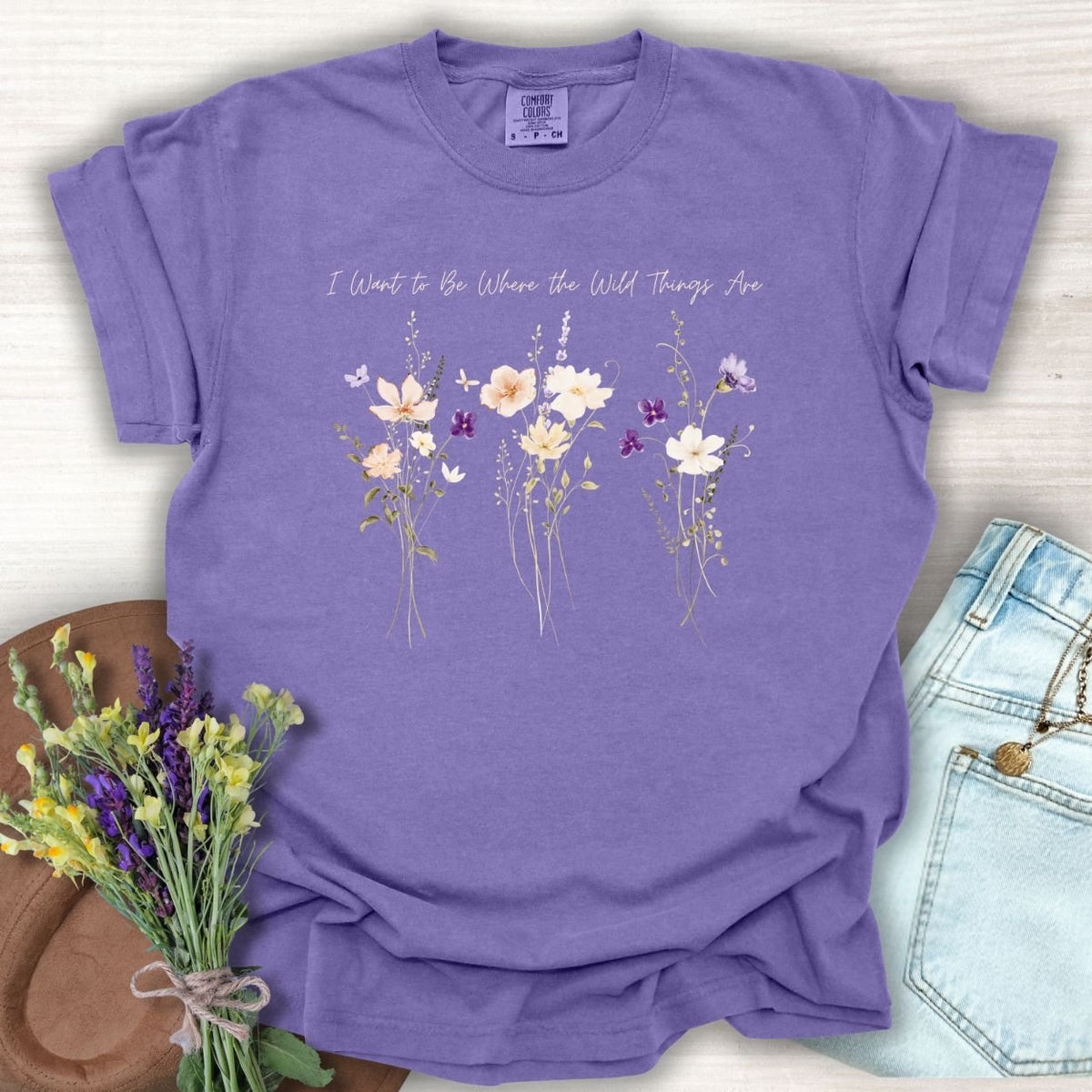 Grape purple garment-dyed cotton t-shirt featuring watercolor wildflowers and the text I Want To Be Where The Wild Things Are.