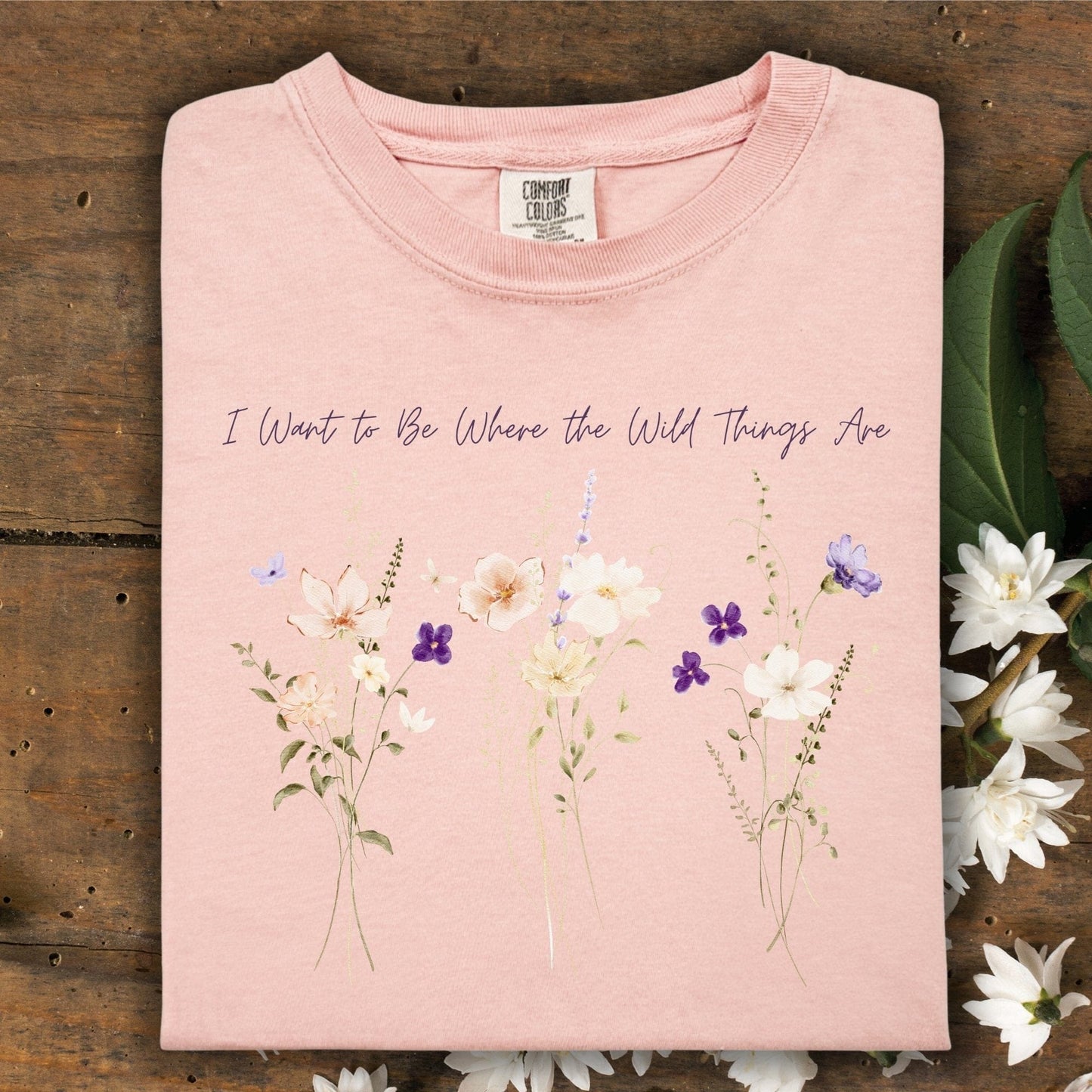 Peachy Comfort Colors t-shirt with "I Want to Be Where the Wild Things Are" text and wildflower graphic.