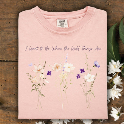 Peachy Comfort Colors t-shirt with "I Want to Be Where the Wild Things Are" text and wildflower graphic.