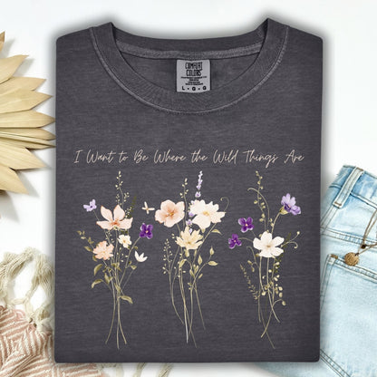 Pepper Comfort Colors t-shirt with "I Want to Be Where the Wild Things Are" and cream/purple wildflowers.