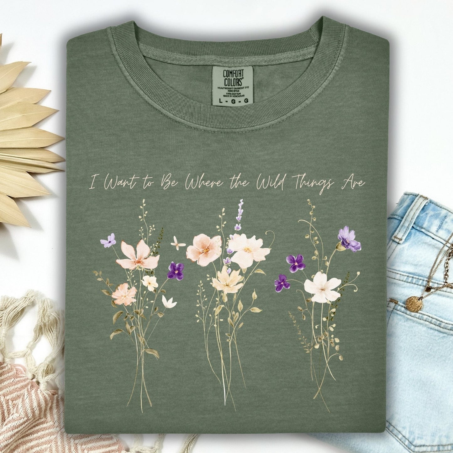 Moss green t-shirt with cream and purple wildflowers and "I Want to Be Where the Wild Things Are" text.