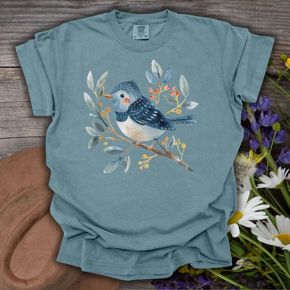 Ice Blue S-size t-shirt with a whimsical bluebird on a branch, surrounded by leaves and berries.