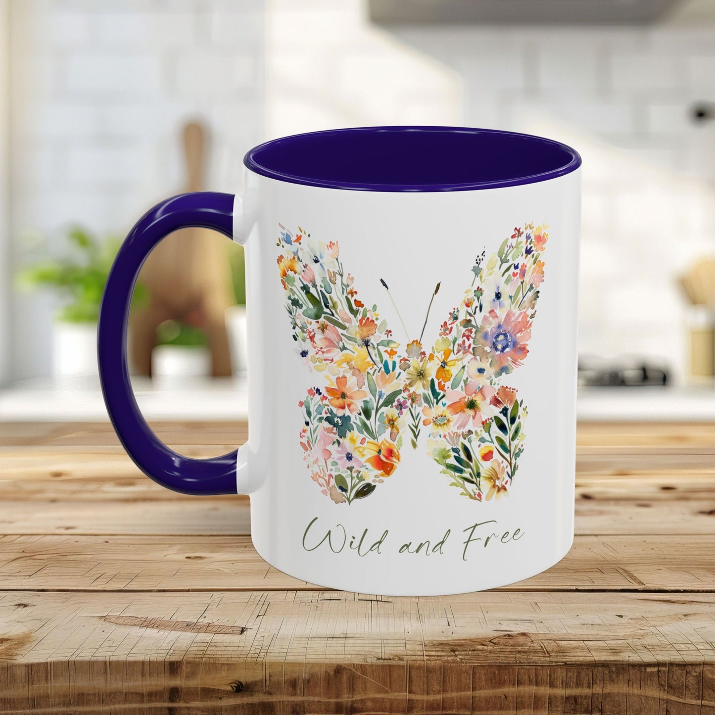 White ceramic mug with a watercolor floral butterfly design, "Wild and Free" text, and a purple handle and interior.