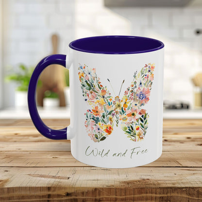 White ceramic mug with a watercolor floral butterfly design, "Wild and Free" text, and a purple handle and interior.