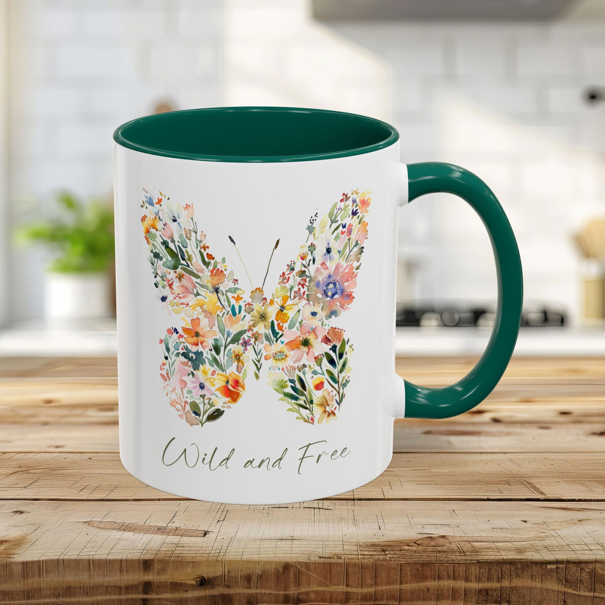 White ceramic 11oz mug with a green interior and handle, featuring a watercolor floral butterfly and "Wild and Free" text.