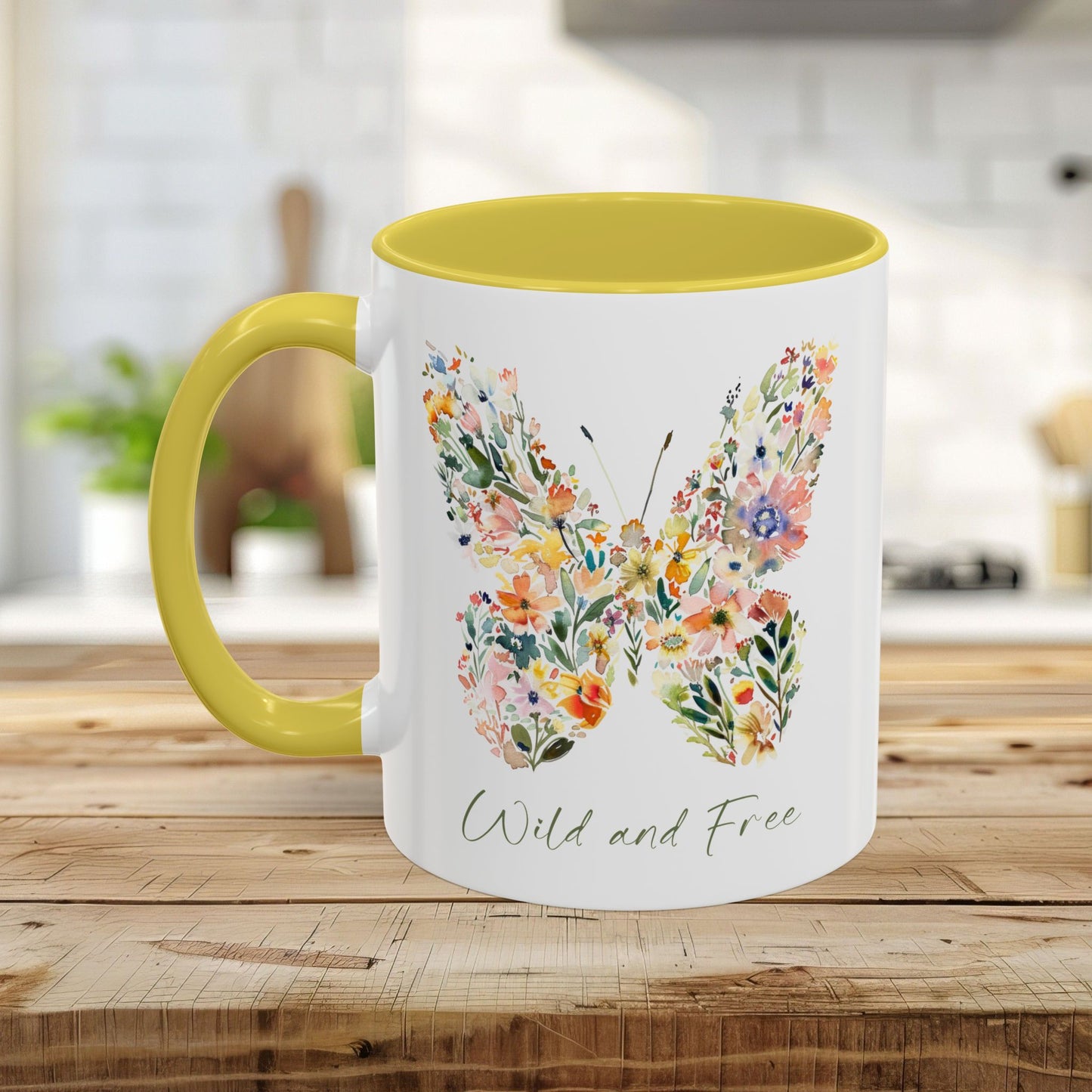 White ceramic mug with a yellow handle and interior, featuring a watercolor floral butterfly and "Wild and Free" text.