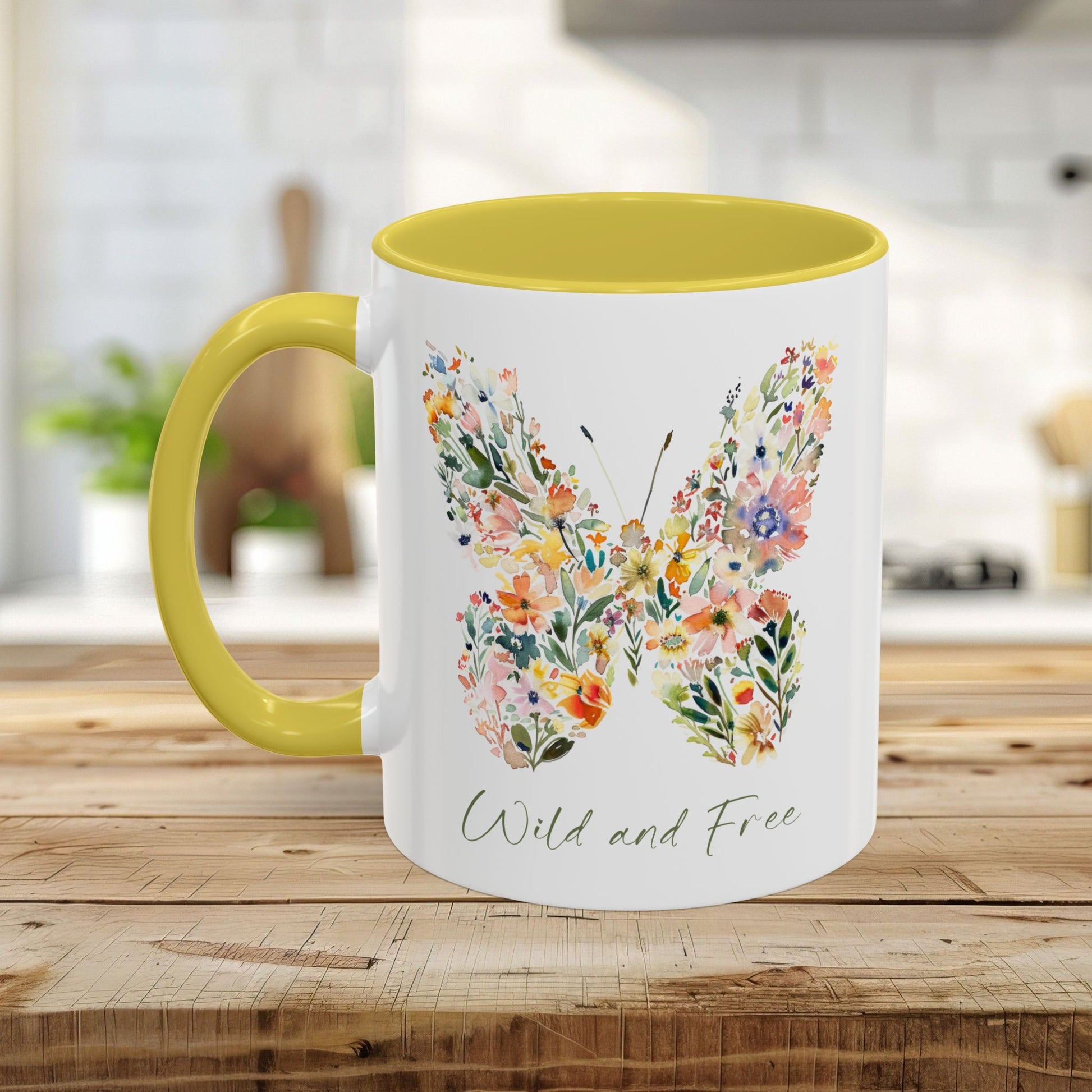 White ceramic mug with a yellow handle and interior, featuring a watercolor floral butterfly and "Wild and Free" text.