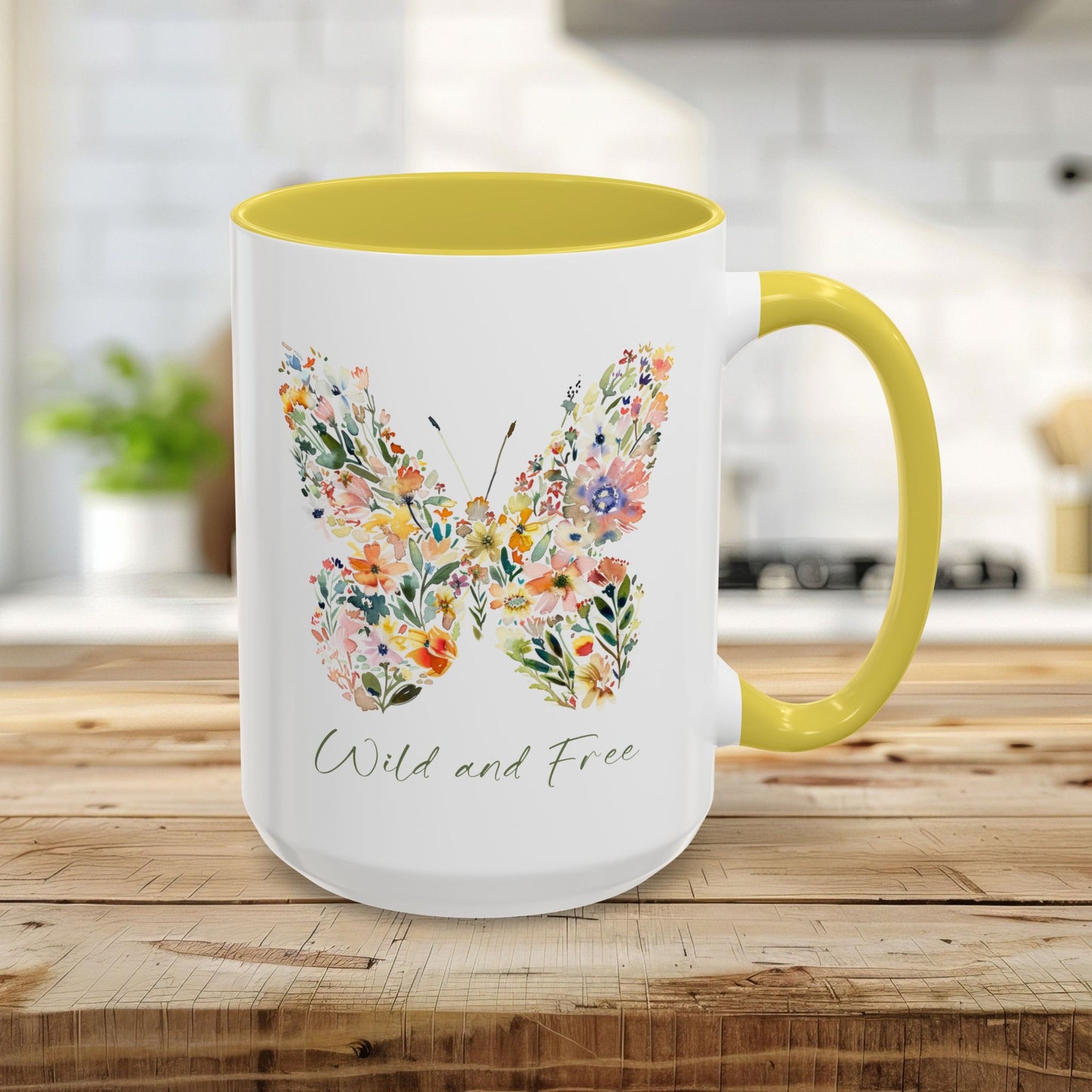 15oz white ceramic mug with yellow interior/handle, featuring a watercolor floral butterfly and "Wild and Free" text.