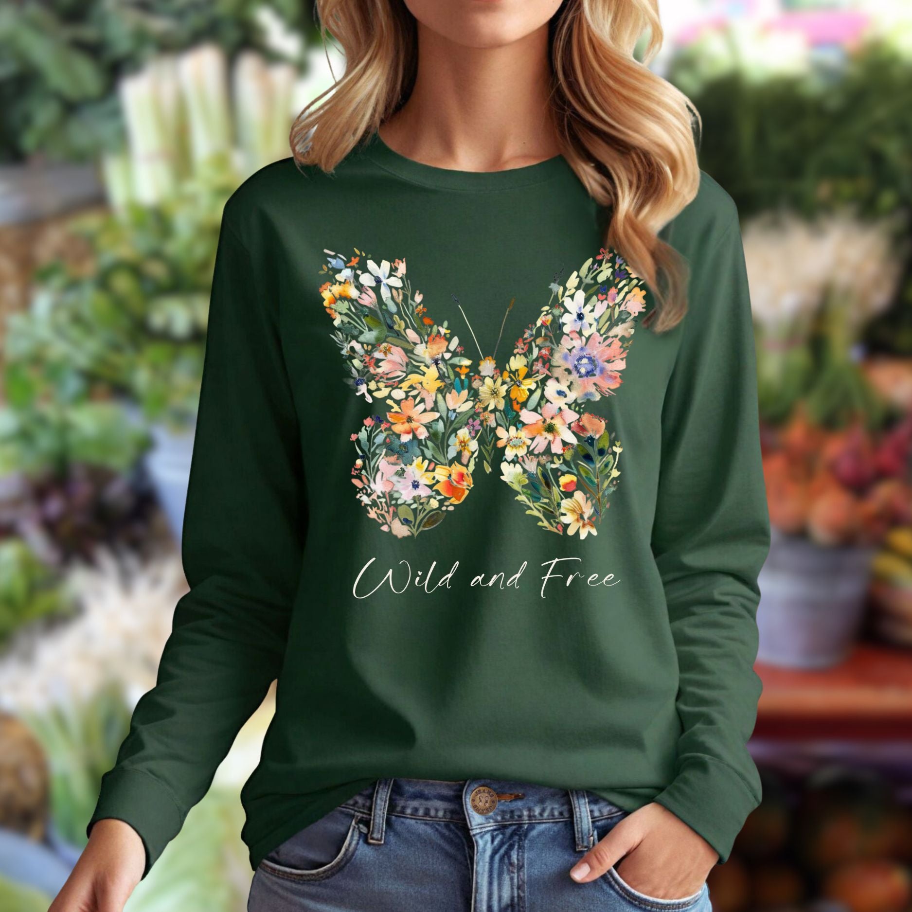 Dark green long-sleeve tee with a colorful wildflower butterfly graphic and "Wild and Free" text.