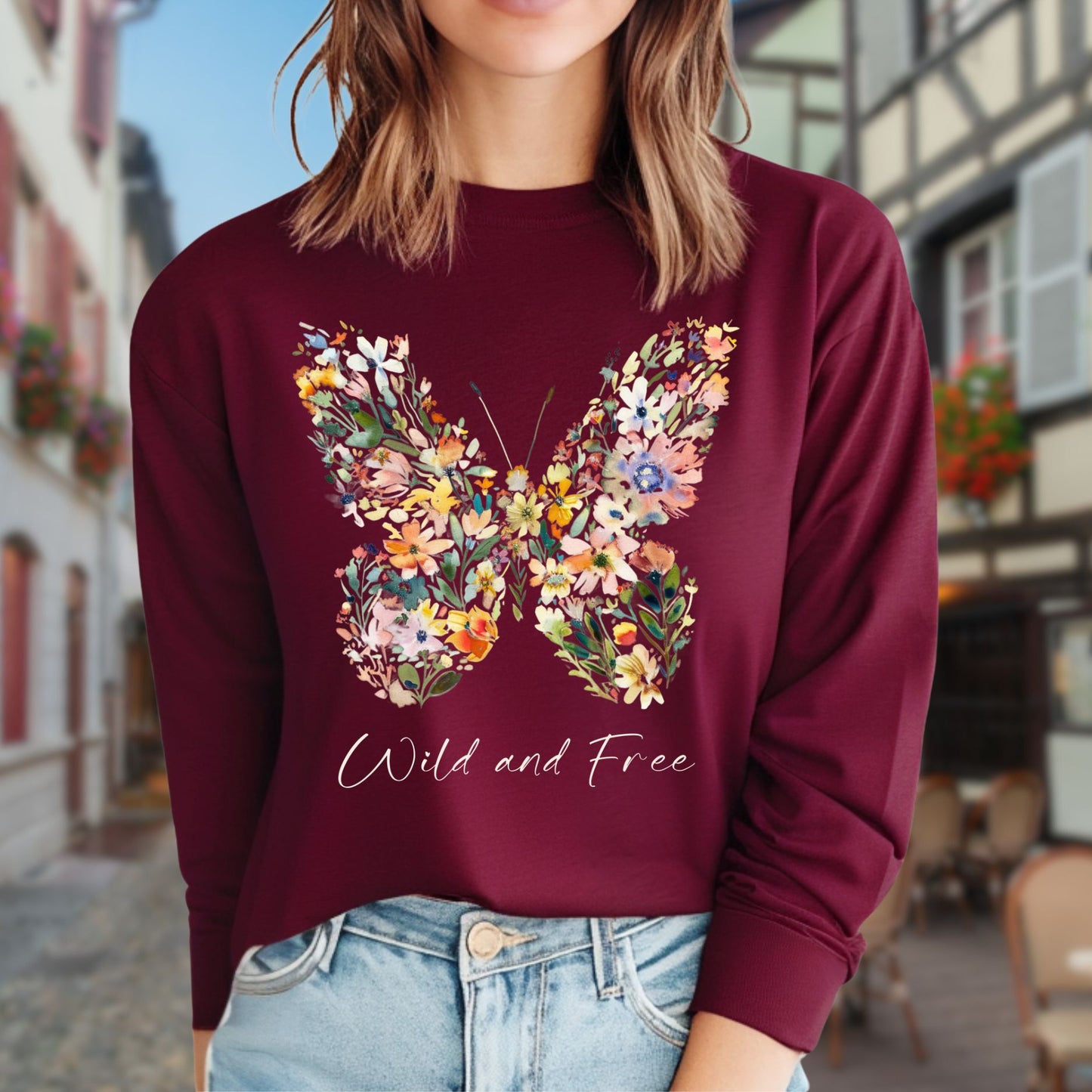 Maroon long-sleeve tee with a colorful wildflower butterfly print and "Wild and Free" text.