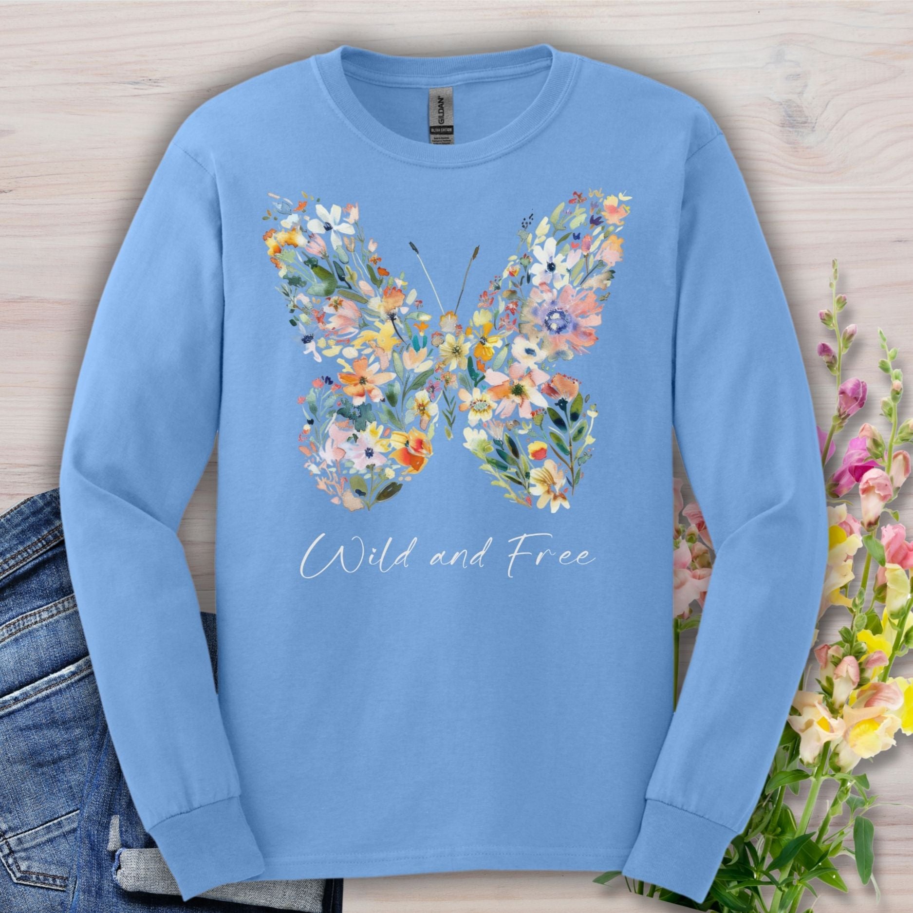Light blue long-sleeve tee with a colorful wildflower butterfly print and "Wild and Free" text.