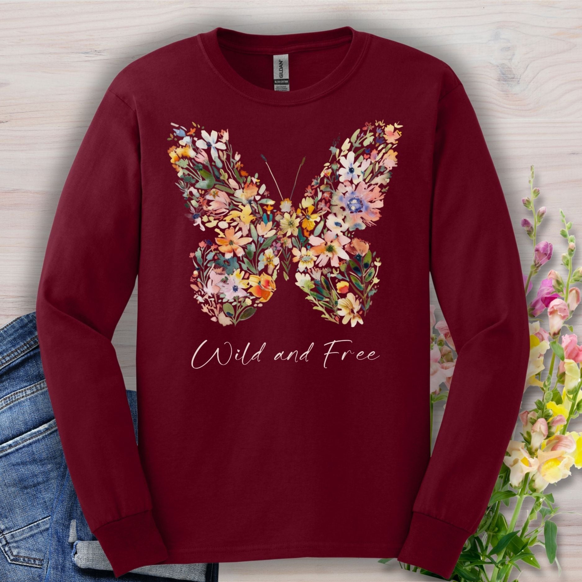 Maroon long-sleeve tee with a colorful wildflower butterfly print and "Wild and Free" text.
