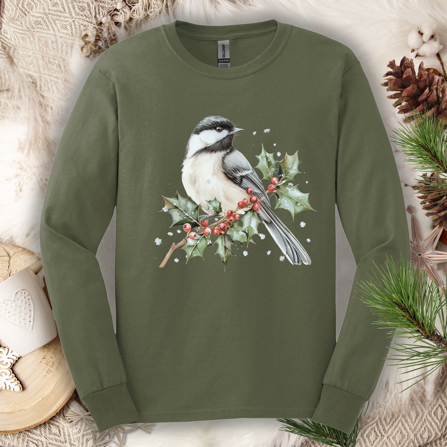 Olive green long sleeve tee with a watercolor chickadee on a snow-dusted holly branch with red berries.