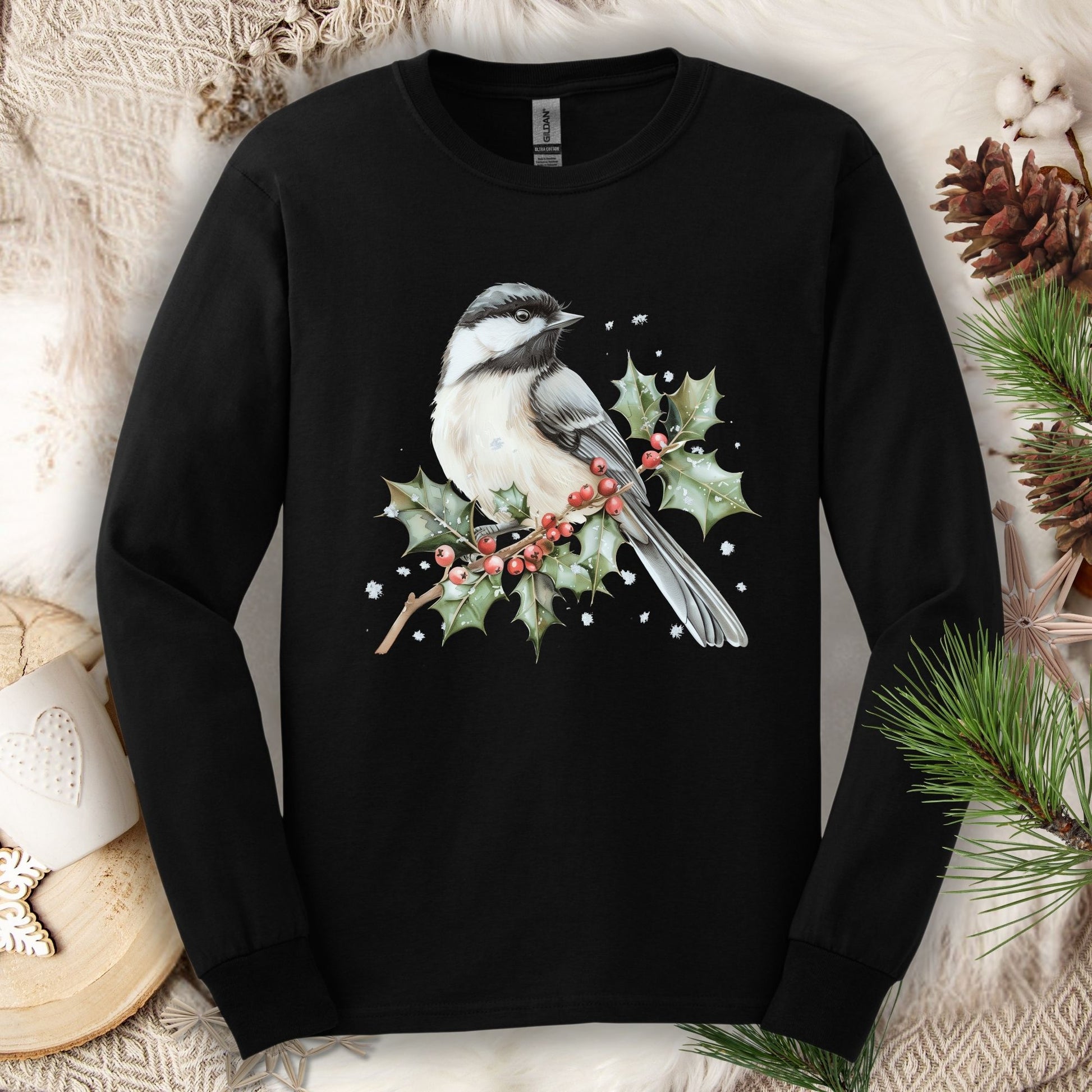 Black long sleeve tee with a watercolor chickadee on a snowy holly branch with red berries.