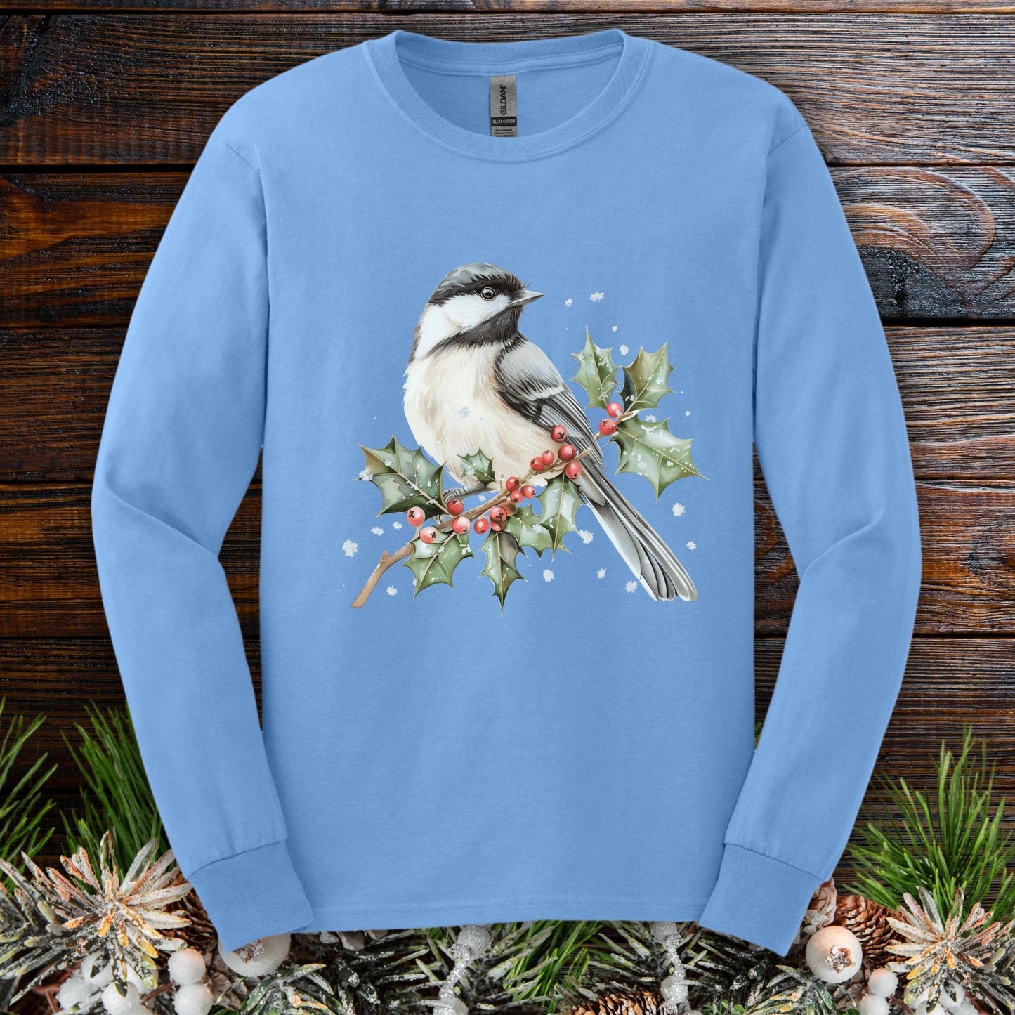 Carolina Blue long sleeve tee with a watercolor chickadee on a snowy holly branch with red berries.