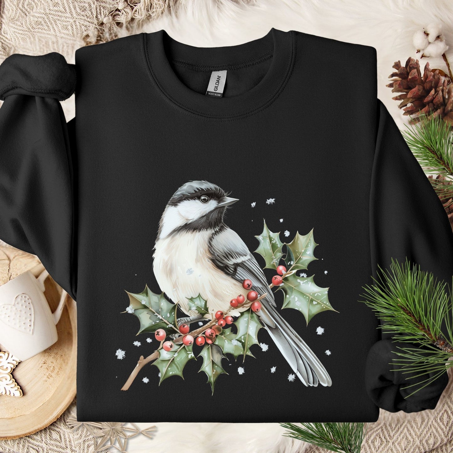 Black heavy blend sweatshirt with a watercolor chickadee on a frosted holly branch design.