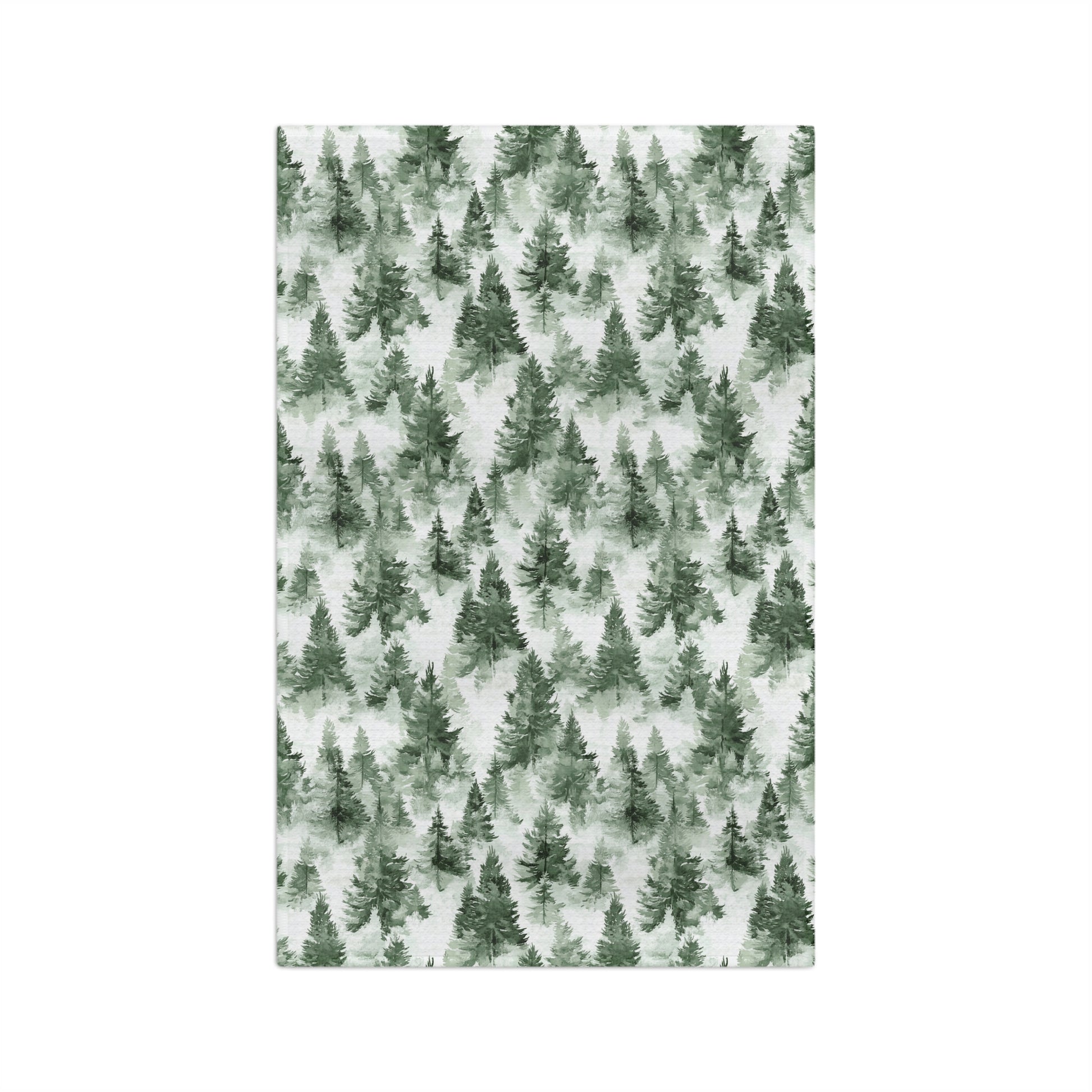 Microfiber tea towel with a painterly deep-green evergreen forest pattern on a white background.