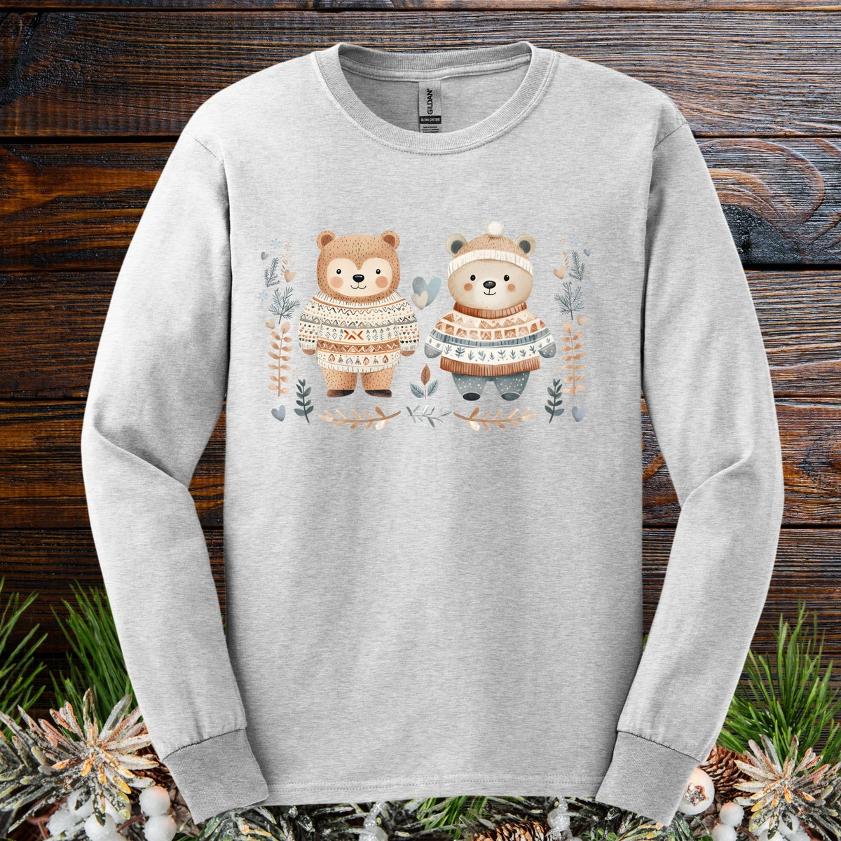 Ash long-sleeve tee with two watercolor bears in fair isle sweaters, winter foliage, hearts, and snowflakes.