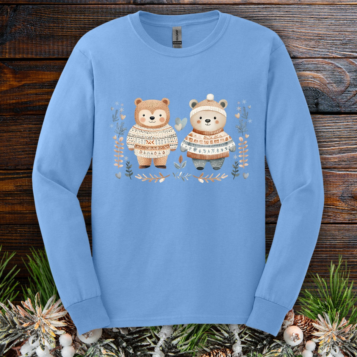 Carolina Blue long sleeve tee with two watercolor bears in Fair Isle sweaters, winter foliage, and snowflakes.
