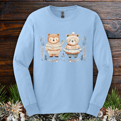 Light blue long sleeve tee with two watercolor bears in fair isle sweaters, winter foliage.