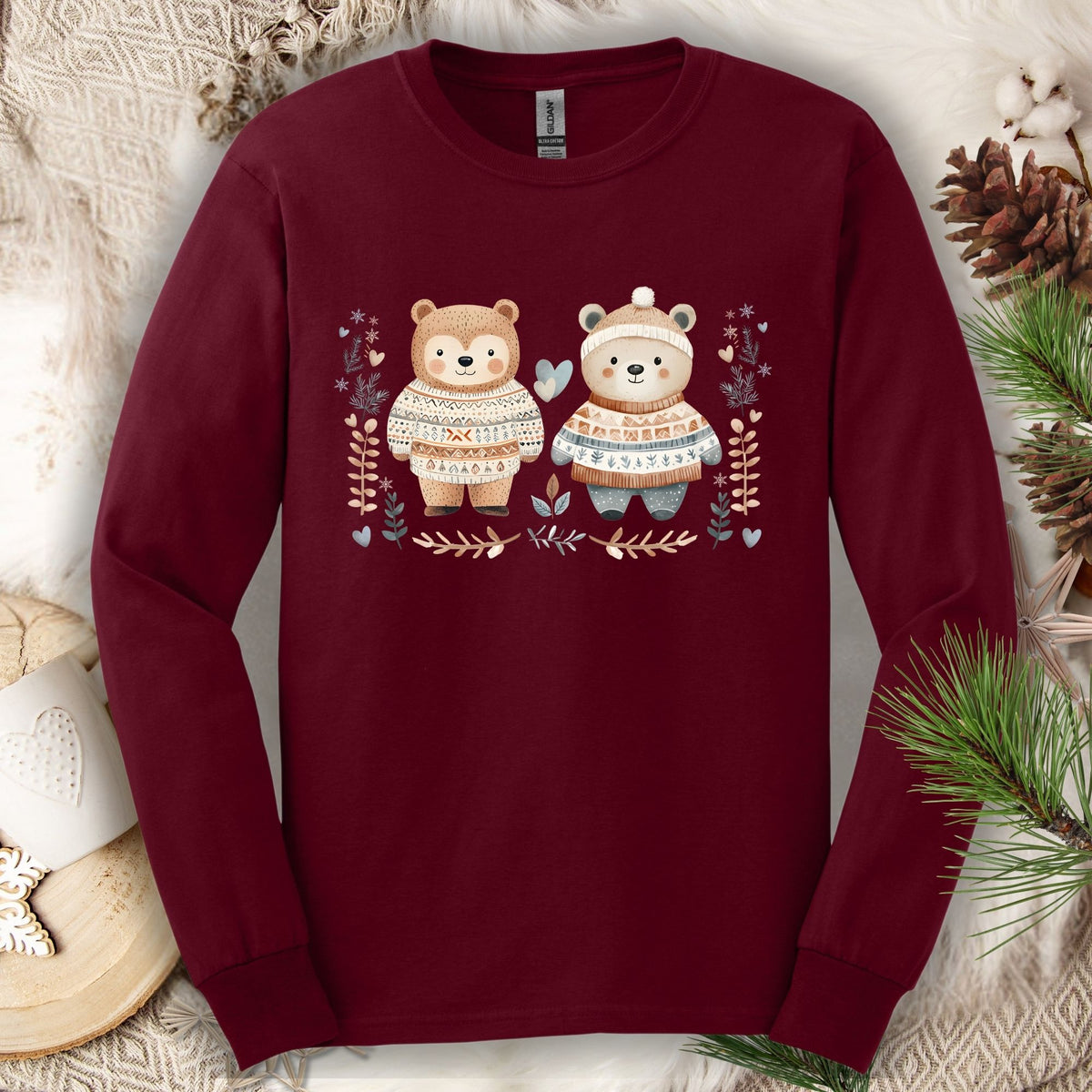 Maroon long-sleeve tee with two watercolor bears in Fair Isle sweaters, winter foliage, hearts, and snowflakes.