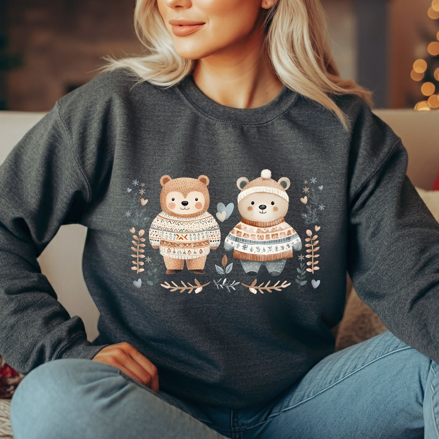 Woman wearing a charcoal gray sweatshirt with two love bears in Fair Isle sweaters, winter foliage, and hearts.