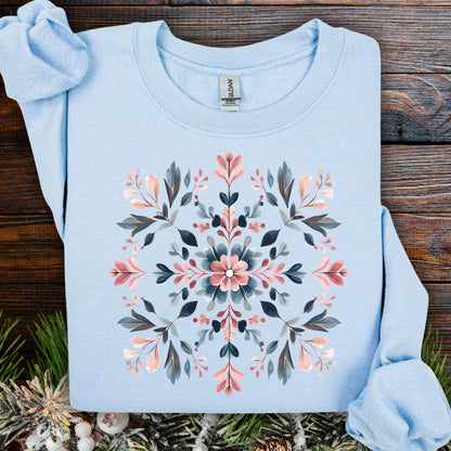 Light blue cotton-poly sweatshirt with a symmetrical floral snowflake design in pink, blue, and gray tones.