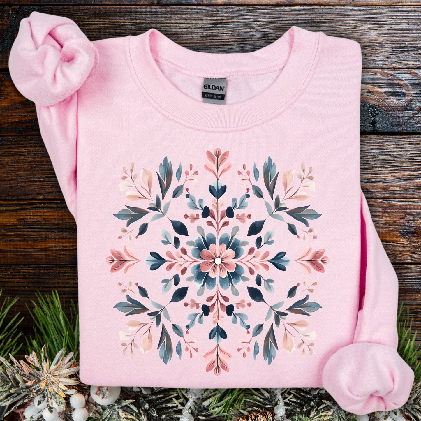 Light pink Gildan cotton-poly sweatshirt with a symmetrical floral snowflake design in muted blues, pinks, and greens.