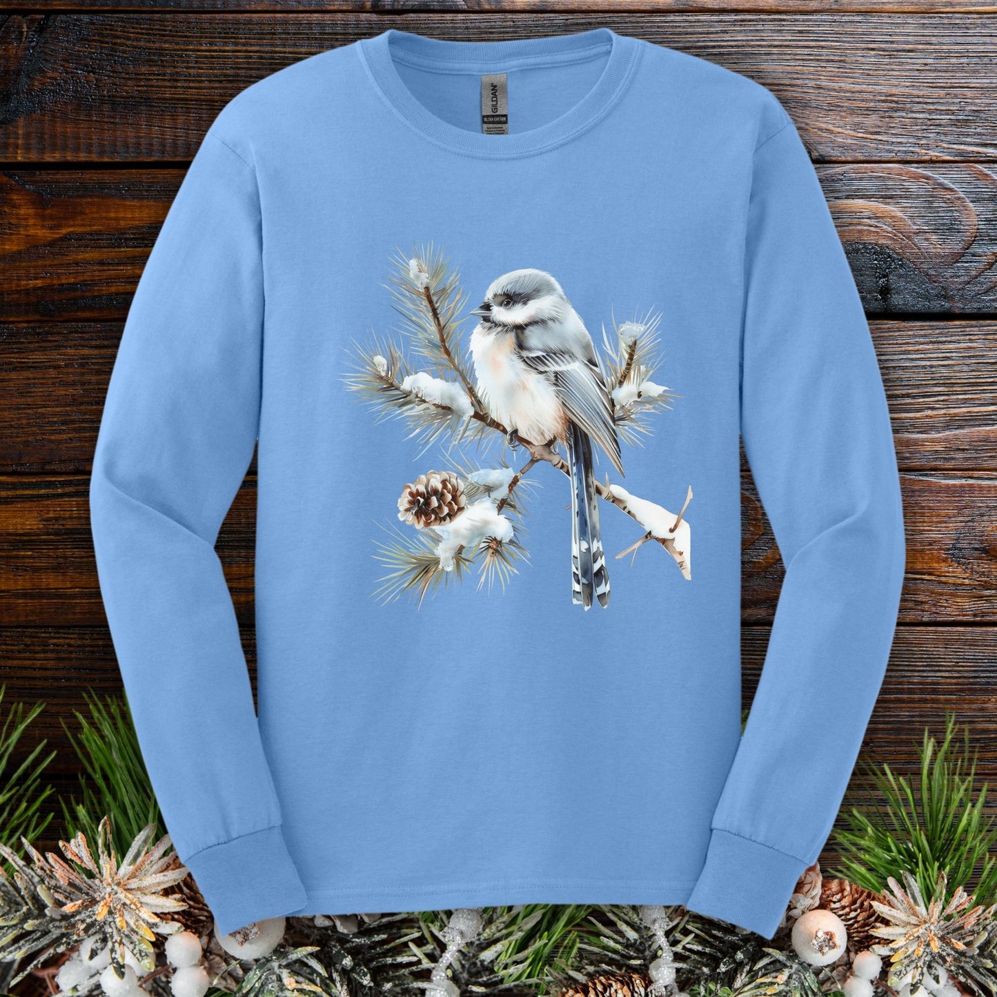 Carolina Blue Gildan 2400 long sleeve tee with watercolor long-tailed tit on snowy evergreen branch.