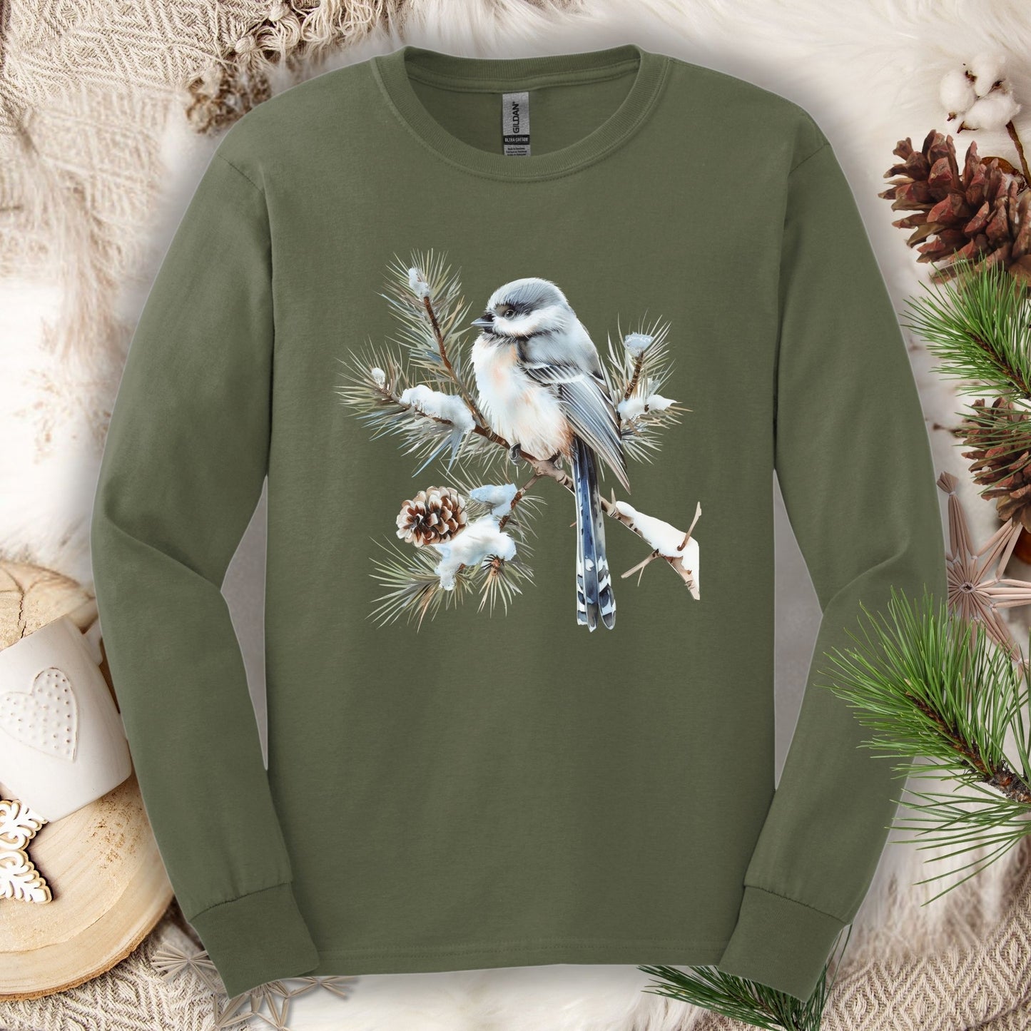 Military Green long-sleeve tee with watercolor long-tailed tit on snowy evergreen branch.